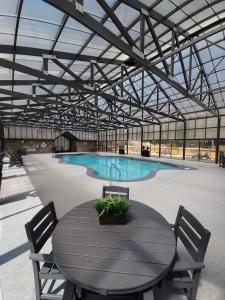 ein Tisch und Stühle in einem Gebäude mit einem Swimmingpool in der Unterkunft Fall Wonders - Dollywood at 2 min & Heated Pool in Sevierville
