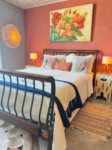 um quarto com uma cama e um quadro na parede em Villa Lulu Geribá em Búzios