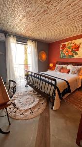 - une chambre avec un grand lit et une grande fenêtre dans l'établissement Villa Lulu Geribá, à Búzios