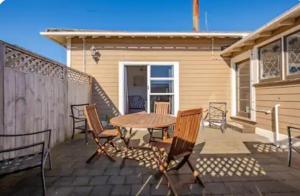 een patio met een tafel en stoelen op een huis bij St Clair Holiday House in Dunedin