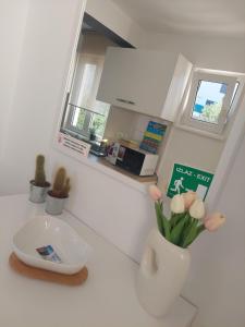 a kitchen with a white vase with flowers in it at Apartmans and rooms Petra in Rab