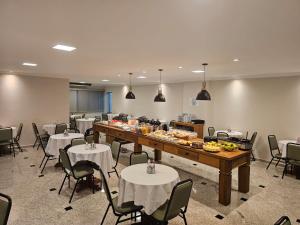 a large room with tables and chairs and a buffet at Hotel Aquarius do Vale in São José dos Campos
