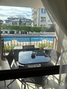 een tafel op een balkon met uitzicht op een zwembad bij Pool apartment on the beach in Boergas +7 foto's