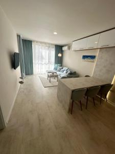 een woonkamer met een tafel en een bank bij Pool apartment on the beach in Boergas