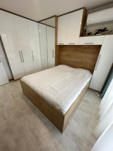 een slaapkamer met een bed en witte kasten bij Pool apartment on the beach in Boergas