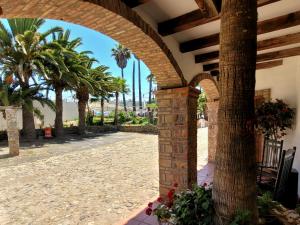 einen Torbogen in einem Resort mit Palmen in der Unterkunft Spanish Style Vacation Home in Rosarito in Primo Tapia