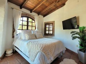 ein Schlafzimmer mit einem Bett und einem TV an der Wand in der Unterkunft Spanish Style Vacation Home in Rosarito in Primo Tapia