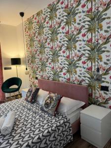 Schlafzimmer mit einem Bett mit Blumentapete in der Unterkunft WhiteHouse_Rooms in Calatabiano