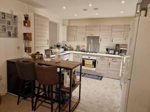 cocina con mesa y nevera en A stunning room in a 2 bed apartments in the heart of Medway, en Gillingham