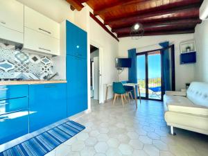 cocina con armarios azules y sala de estar. en Dreamy Seaside en Bari Sardo