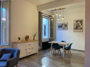 a living room with a dining room table and chairs at Appartement coquet dans le centre de Mèze in Mèze