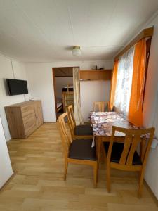 a dining room with a table and chairs and a television at Chaty Dobrá Voda 86 in Horní Planá