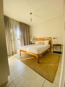 ein Schlafzimmer mit einem Bett und einem großen Fenster in der Unterkunft Stunning 3Bed 2bath Oasis W King Bed in Midrand