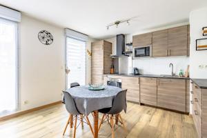een keuken met een tafel en stoelen in een kamer bij Sweet Dreams in Honfleur