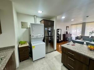 a kitchen with a refrigerator and a tv in it at Maravilloso departamento con moto electricá in Cuenca