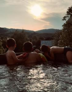 une femme et deux enfants dans une piscine dans l'établissement Beztroska Chata Bieszczady, à Mchawa