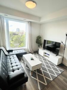 ウォータールーにあるModern Queen Room-Private Bathroomのソファとテレビのあるリビングルーム
