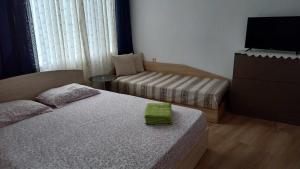 - une petite chambre avec 2 lits et une télévision dans l'établissement Апартамент-идеален център Ямбол, à Yambol