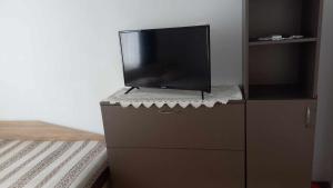 - une télévision à écran plat assise sur une commode dans l'établissement Апартамент-идеален център Ямбол, à Yambol