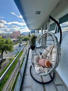 a hammock on a balcony with a view of a street at Maravilloso departamento con moto electricá in Cuenca