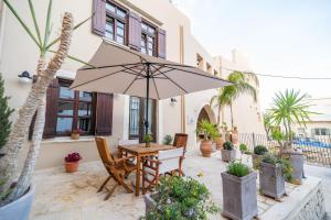 a patio with a table and chairs and an umbrella at Lithinon Luxury Suites Old Town Chania free on-site Parking in Chania
