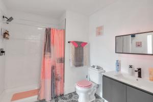 a bathroom with a pink shower curtain and a toilet at Pink Heaven in Elizabeth