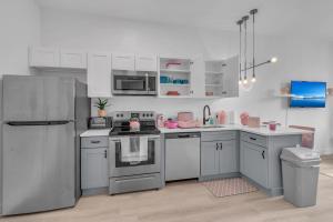 a kitchen with white cabinets and a stainless steel refrigerator at Pink Heaven in Elizabeth