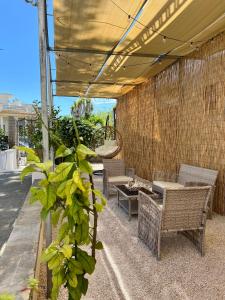 eine Terrasse mit Stühlen und Tischen sowie ein Gebäude in der Unterkunft Terrazza Levante in Otranto