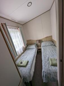 ein kleines Zimmer mit 2 Betten und einem Fenster in der Unterkunft Abi the Sand castle in Port Seton