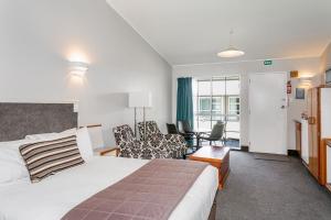 um quarto de hotel com uma cama e uma sala de estar em Turangi Leisure Lodge em Turangi