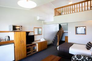 Turangi Leisure Lodge في تورانجي: غرفه فندقيه بسرير ودرج