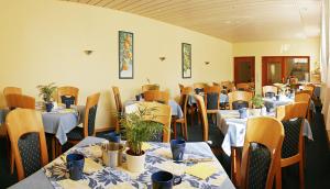 a dining room with tables and chairs with plants on them at Pension Keinath in Stuttgart