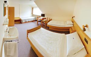 a hospital room with two beds and a sink at Pension Keinath in Stuttgart