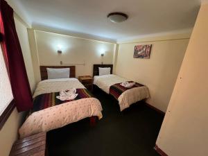 Кровать или кровати в номере HOSTAL HUAYNA HOUSE GO