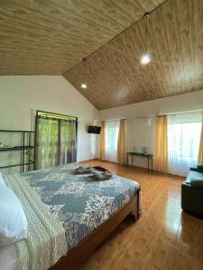 a bedroom with a bed with a blue comforter at Cabañas el Bosque del Arenal in Guayabal