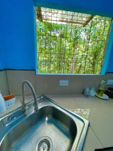 a sink in a kitchen with a window at Cabañas el Bosque del Arenal in Guayabal +28 photos