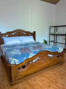 a bed with a wooden frame in a bedroom at Cabañas el Bosque del Arenal in Guayabal