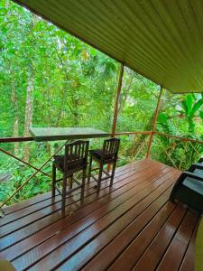 a screened in porch with two chairs and a table at Cabañas el Bosque del Arenal in Guayabal