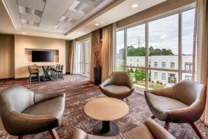 a lobby with chairs and a table and a large window at Courtyard by Marriott Atlanta Duluth Downtown in Duluth