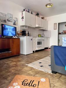 uma cozinha com armários brancos e uma televisão em Civico 19 em Belmonte Piceno