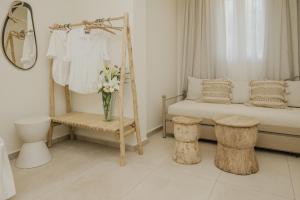 a white bedroom with a bed and a mirror and flowers at Le Jardin apartments in Kámpos +94 photos