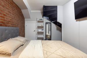 1 dormitorio con cama y pared de ladrillo en Cozy Room at a shared Apartment East Village, en Nueva York