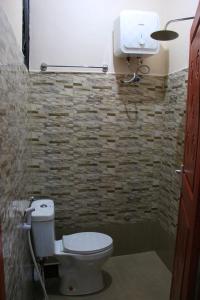 een badkamer met een toilet en een watertank bij Dahari Home Hostel in Moshi