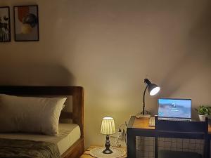 een slaapkamer met een bed en een bureau met een laptop bij Dahari Home Hostel in Moshi