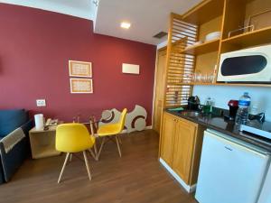 uma cozinha com uma mesa e duas cadeiras amarelas em Comfort Flat Pinheiros em Hotel 4,5 estrelas em São Paulo