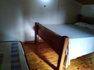 Cama en habitación con suelo de madera en Munay Travel camp, en San Carlos