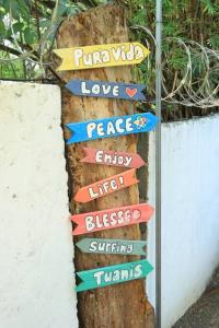 a sign on a tree with different signs on it at Cabaña Viento - RiverBeach in Jacó