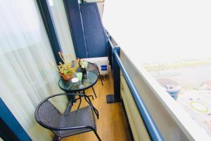a balcony with a table and chairs and a window at Orbi City Sea Side Aparthotel in Batumi