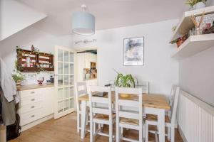 A Spacious 2 Bed Home in a Central Location في بيشوبس ستورتفورد: مطبخ مع طاولة طعام وكراسي بيضاء