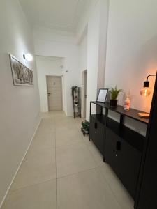 un pasillo con una cómoda negra en una habitación blanca en Valguarnera Studio Apartments, en Palermo